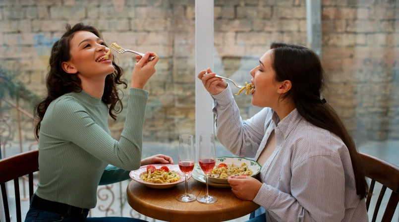 Mãe e filha felizes comendo macarrão